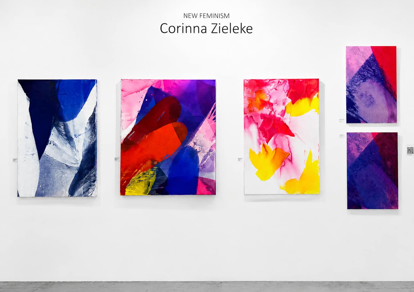 An einer Galeriewand sind fünf farbenfrohe abstrakte Gemälde von Corinna Zieleke mit dem Titel „NEW FEMINISM“ zu sehen, die sich durch kräftige Pinselstriche und leuchtende Blau-, Rosa-, Rot-, Gelb- und Weißtöne auf weißem Hintergrund auszeichnen.