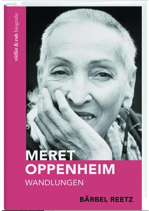 (c)Baerbel-Reetz-Meret-Oppenheim.-Wandlungen-rueffer-rub-Verlag-Zuerich. Buchcover mit einem Schwarz-Weiß-Porträt von Meret Oppenheim, die mit der Hand am Kinn lächelt. Der Titel lautet „Meret Oppenheim Wandlungen“ von Bärbel Reetz, darunter ein rosa-weißer Farbblock.
